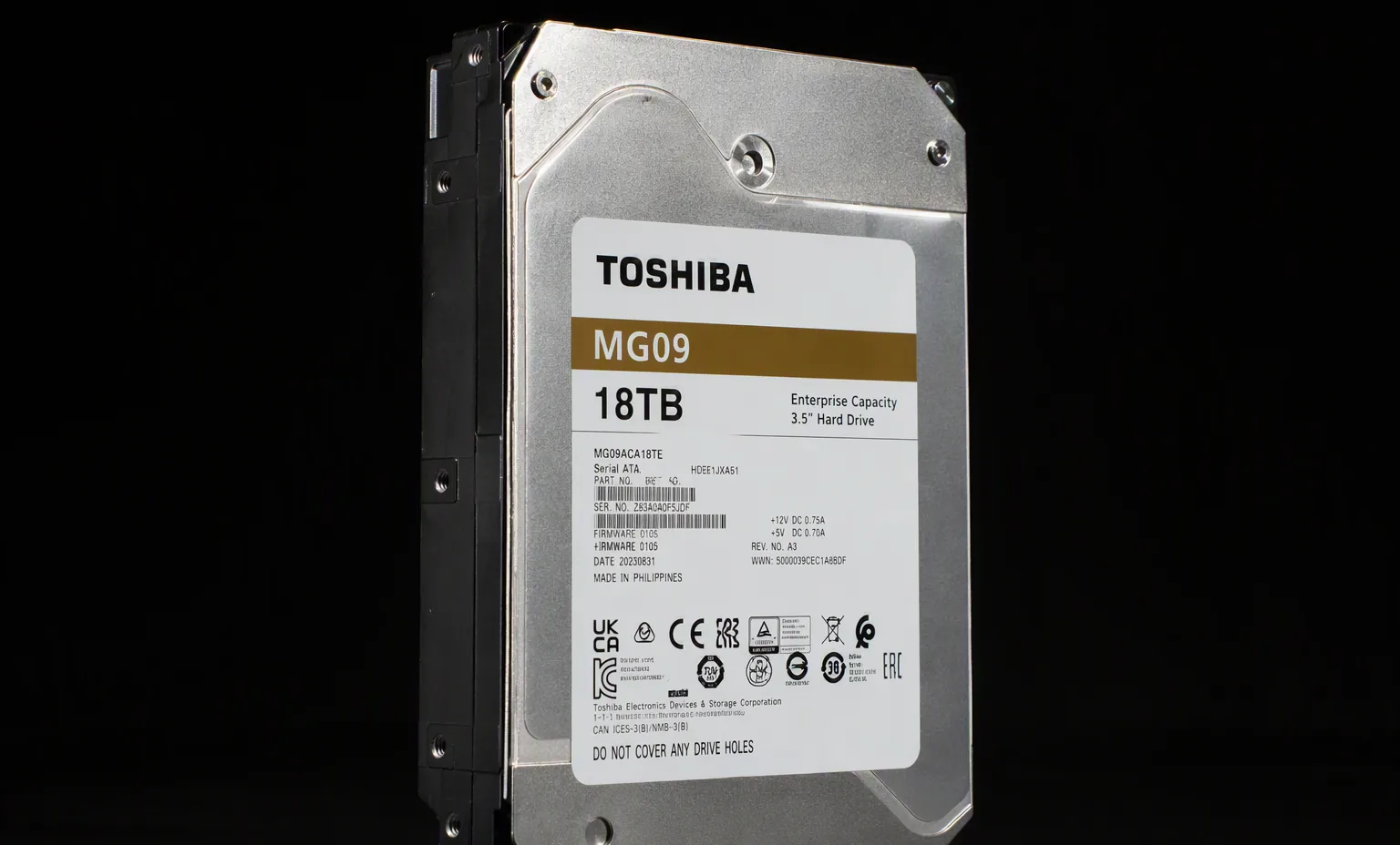Toshiba MG09 18TB enterprise hard drive three-quarter angle view, dark studio background.